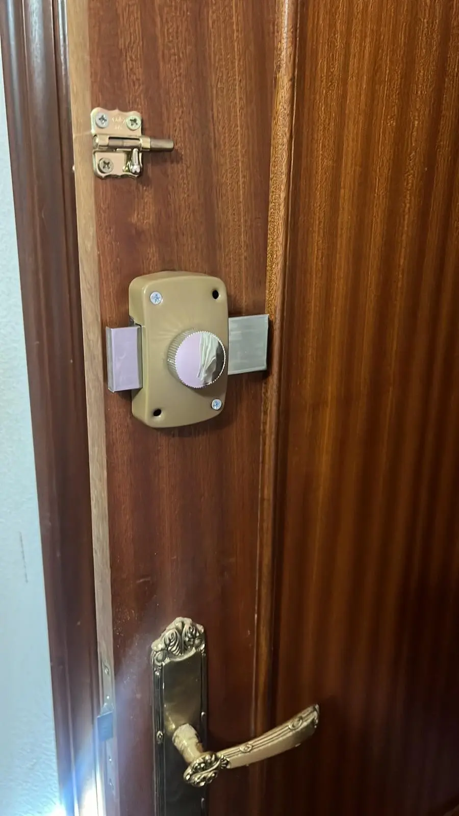 Cerradura de sobreponer con pomo instalada en la puerta de una habitación