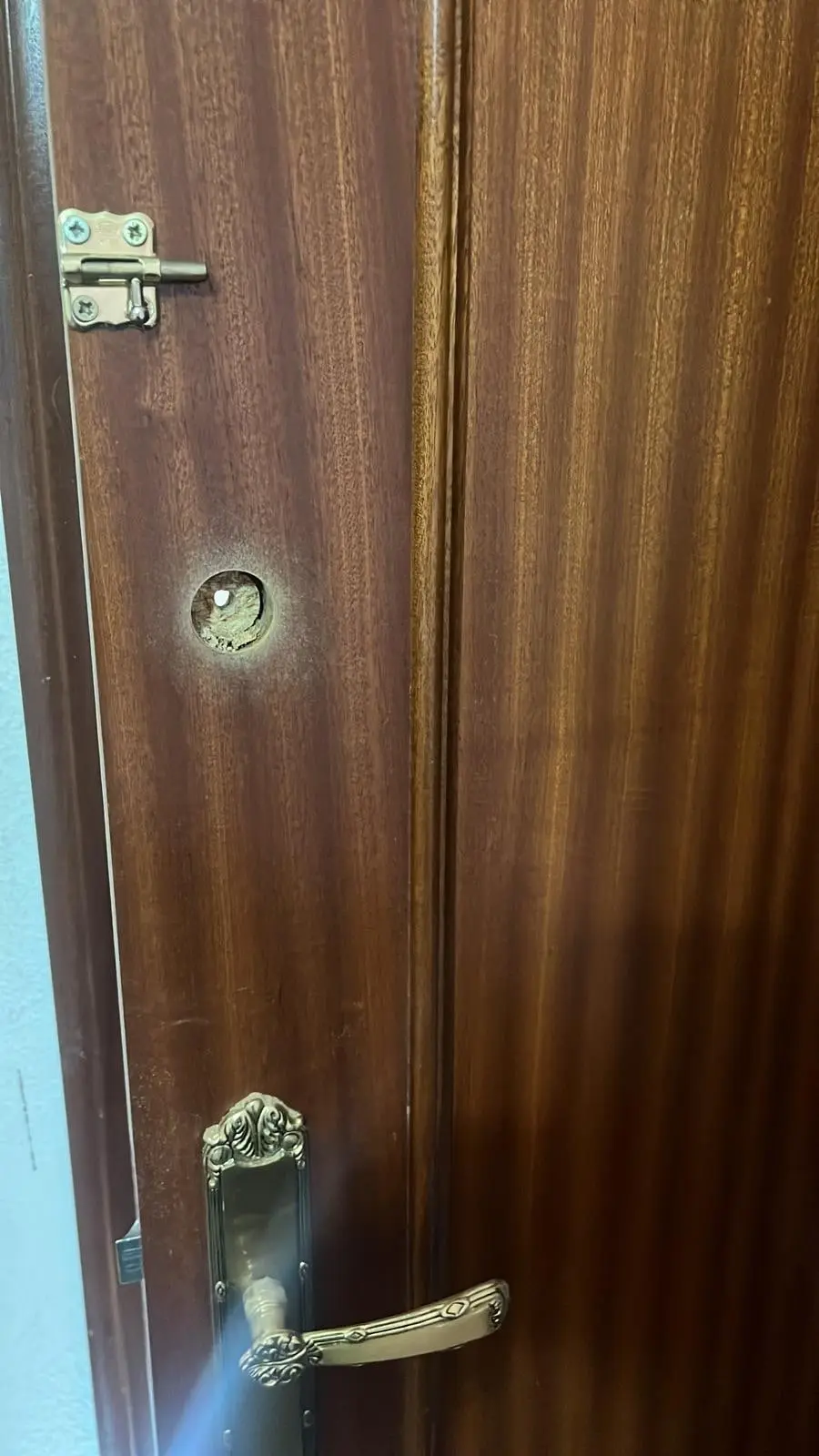Puerta interior de una habitación con el taladro hecho para la cerradura nueva